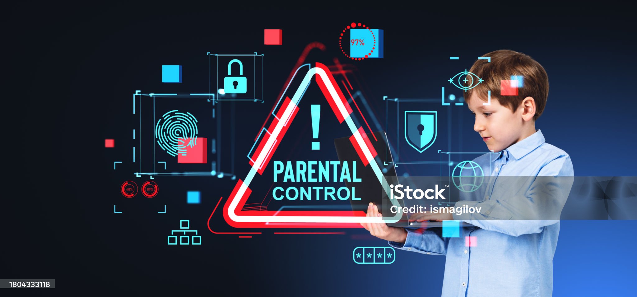 Portrait of serious boy in blue shirt holding laptop standing over blue background with glowing parental control alert sign. Concept of online protection of children and cyber security